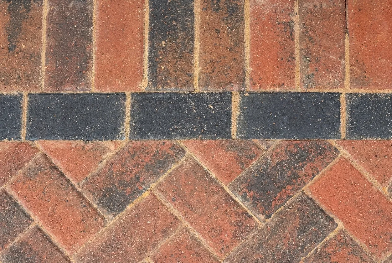 Close-up of the herringbone blocks cut at an angle against the single charcoal border row.