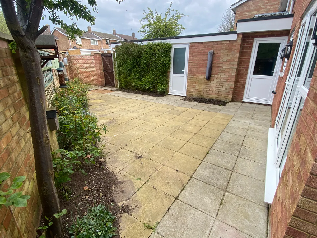 Before: a small Langford garden paved wall to wall in worn concrete slabs, with no planting