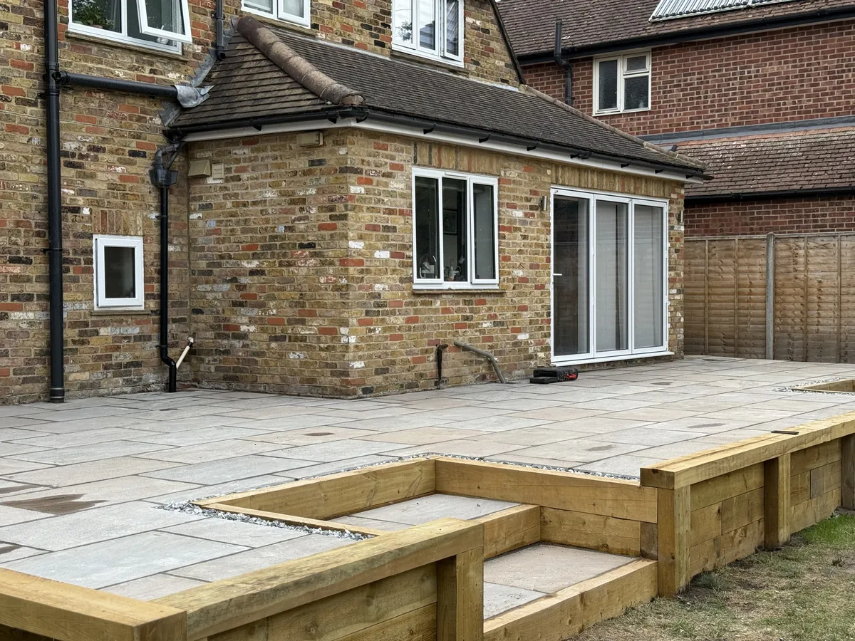 Finished Autumn Brown sandstone elevated terrace raised to house height in a Chalfont garden.