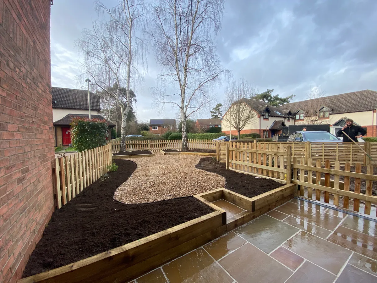 Finished two-tier sandstone terrace and shingle area on a reclaimed slope in Welwyn.